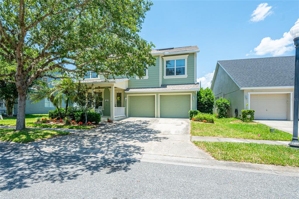 A two-story green house with a two-car garage and a front porch under a tree — 4930 ATWOOD DRIVE, ORLANDO, FL