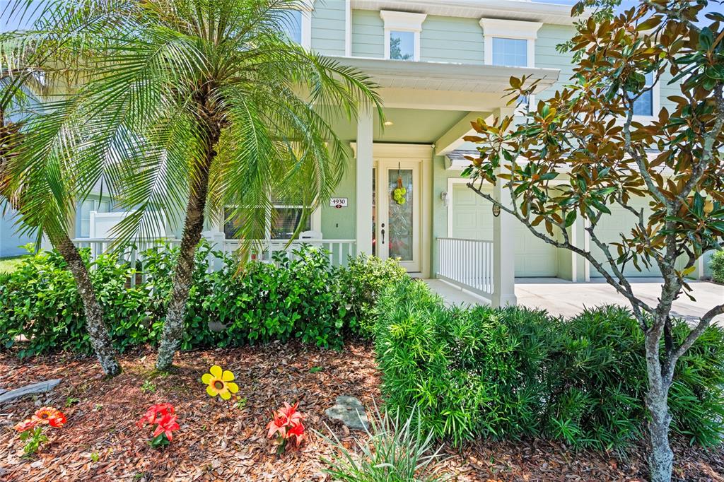 A light green two-story house features a front porch, palm tree, and landscaped garden — 4930 ATWOOD DRIVE, ORLANDO, FL