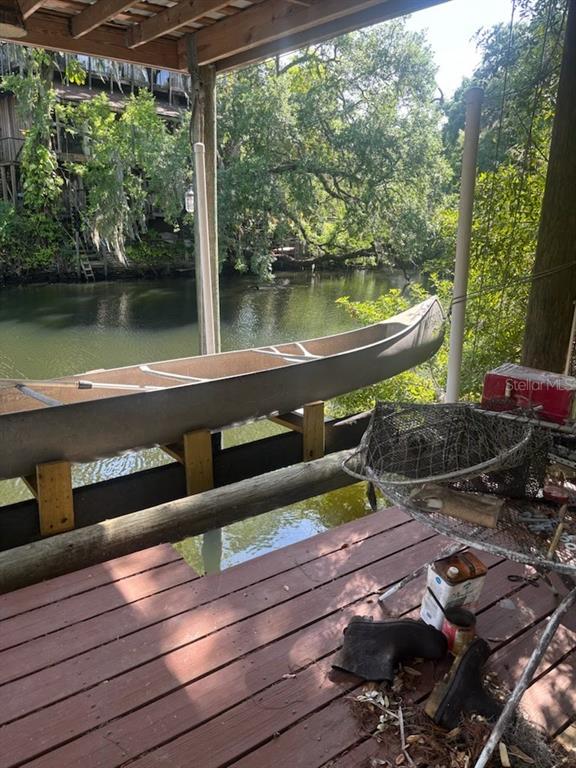 A canoe rests on a wooden rack overlooking a river from a covered deck — 7801 N 12TH STREET, TAMPA, FL