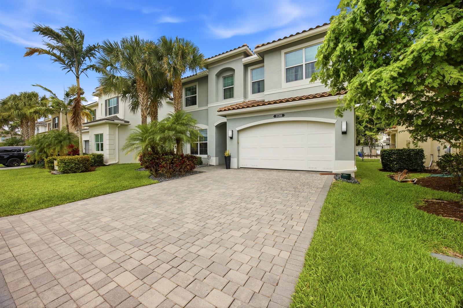 A two-story house with a paved driveway, a two-car garage, and palm trees in front — 15388 Destiny Drive, Delray Beach FL 33446, DELRAY BEACH, FL