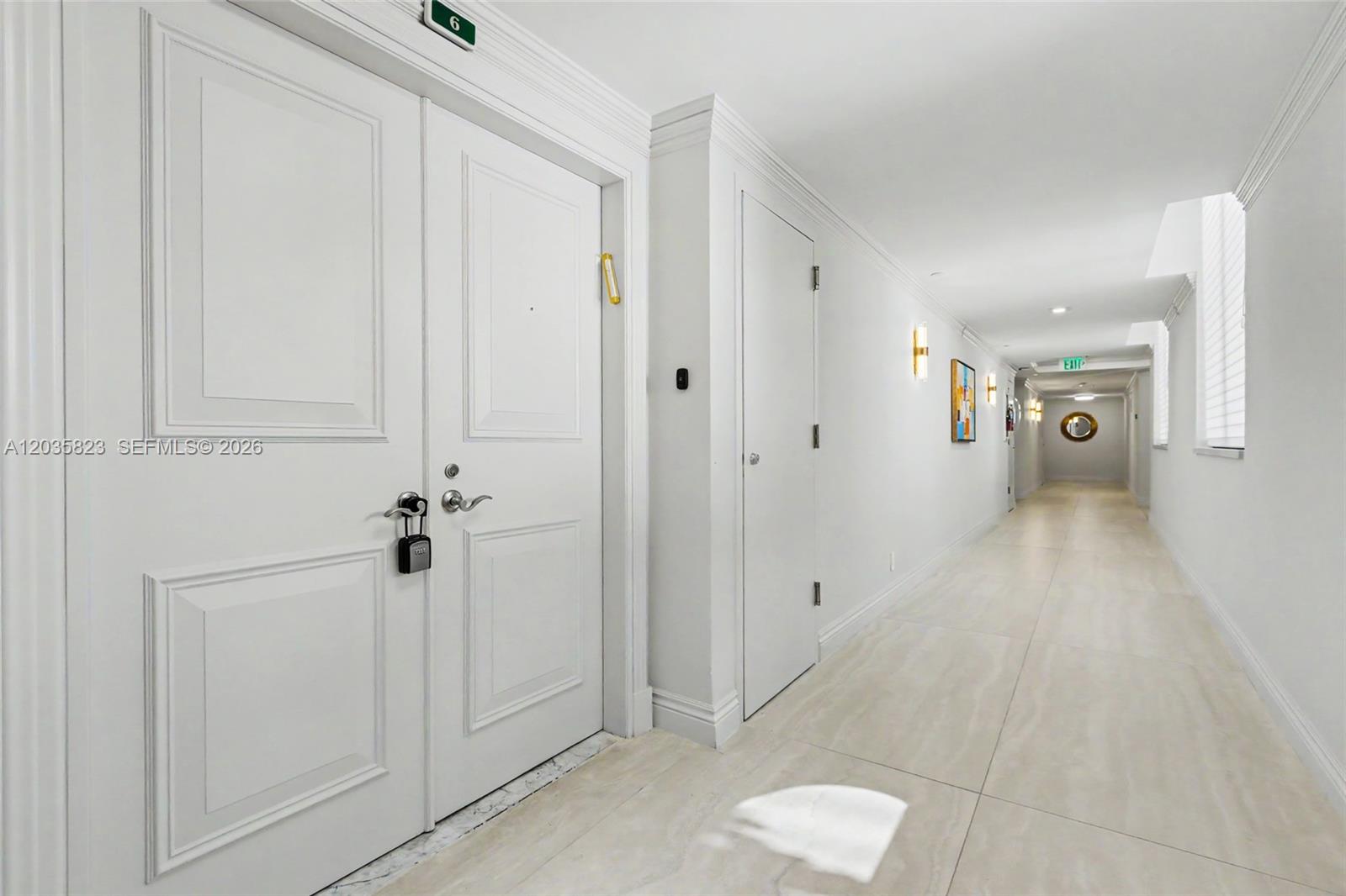 A white hallway features a double-door entrance with a lockbox and tiled flooring — 3801 NE 207th St, Aventura FL 33180, AVENTURA, FL