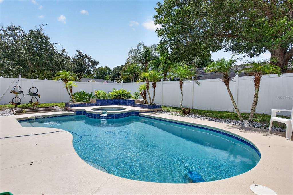 A backyard features a swimming pool with an attached spa and a white privacy fence — 1418 PRINCESS PAULA DRIVE, PORT ORANGE, FL