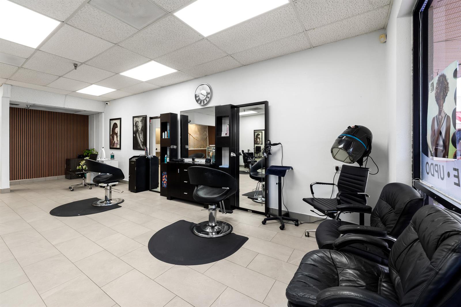 A hair salon features two styling stations, black leather chairs, and a hair dryer — 4608 South Jog Road, FL 33467, FL