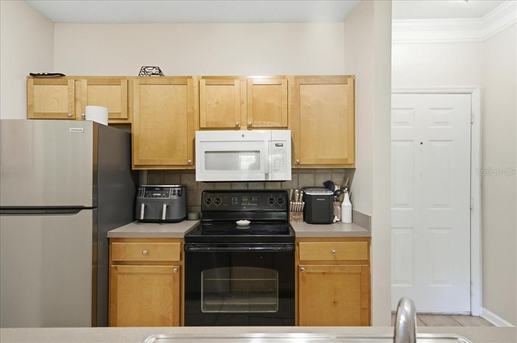 A kitchen features light wood cabinets, stainless steel appliances, and a gray countertop — 4207 S DALE MABRY HIGHWAY UNIT 5307, TAMPA, FL