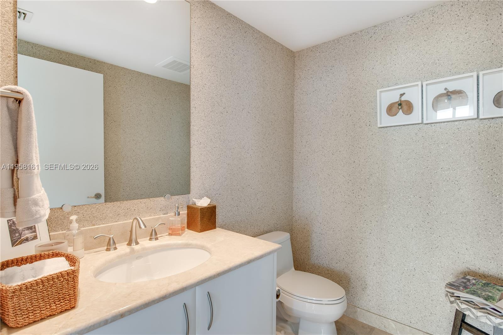A bathroom features a vanity with a stone countertop, a mirror, and textured wallpaper — 1331 Brickell Bay Dr # 3311, Miami FL 33131, MIAMI, FL