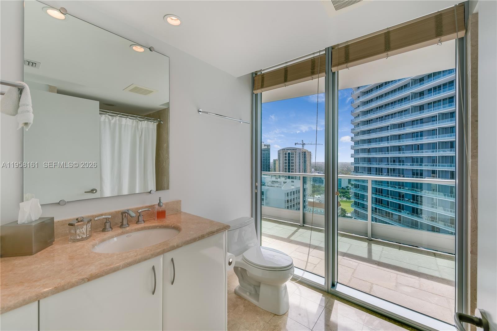 A bathroom features a vanity with a stone countertop, a toilet, and floor-to-ceiling windows — 1331 Brickell Bay Dr # 3311, Miami FL 33131, MIAMI, FL