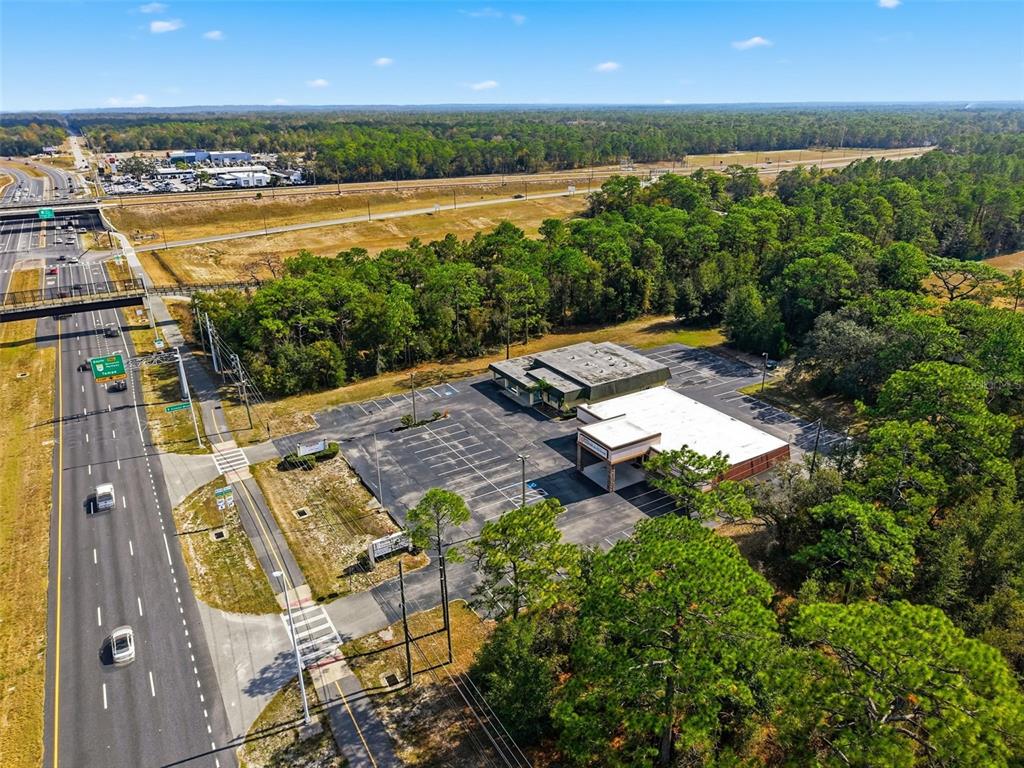 An aerial view shows a commercial building with a parking lot next to a highway — 15010 CORTEZ BOULEVARD, BROOKSVILLE, FL