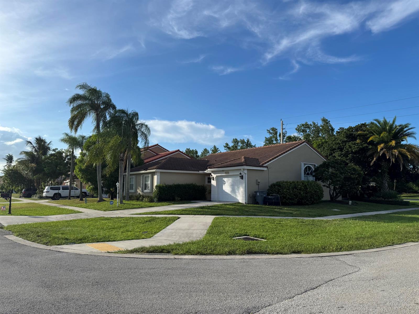 A single-story house with a tiled roof, white garage, and palm trees in the yard — 18750 Caspian Circle, Boca Raton FL 33496, BOCA RATON, FL