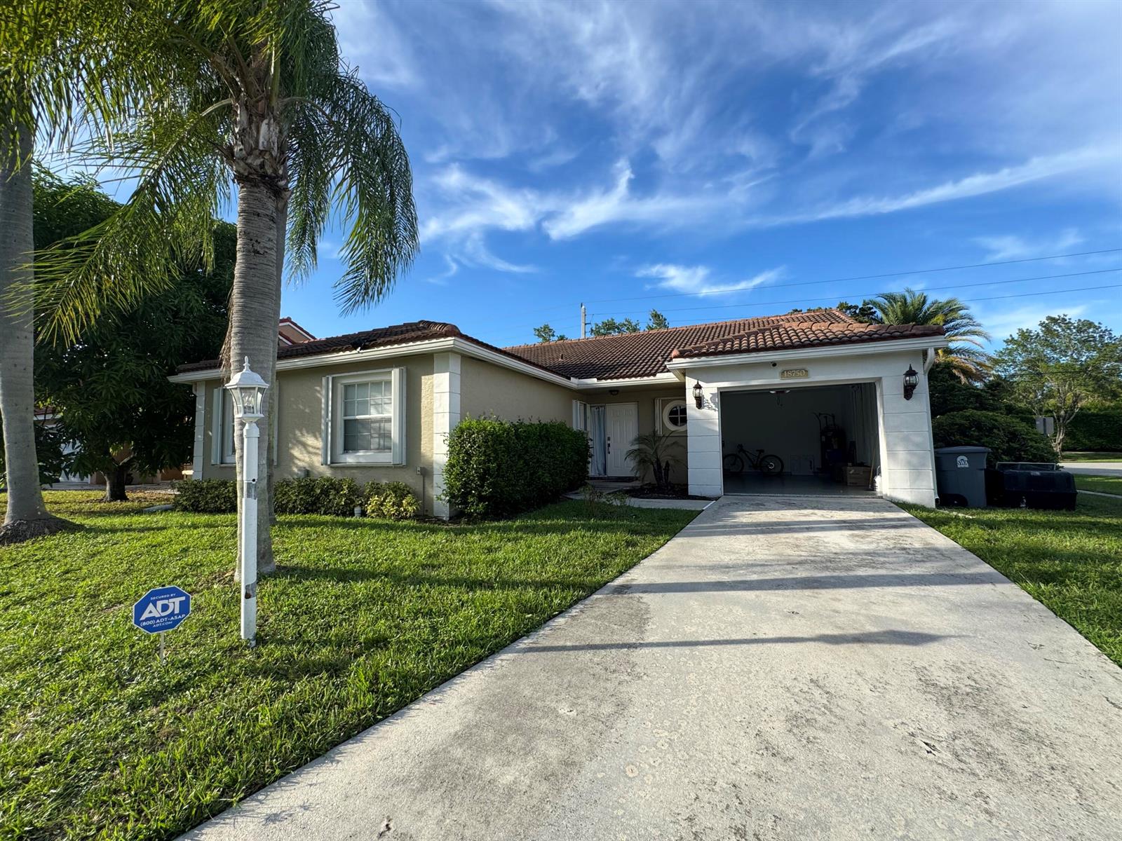 A single-story house with a tile roof, a concrete driveway, and a palm tree — 18750 Caspian Circle, Boca Raton FL 33496, BOCA RATON, FL