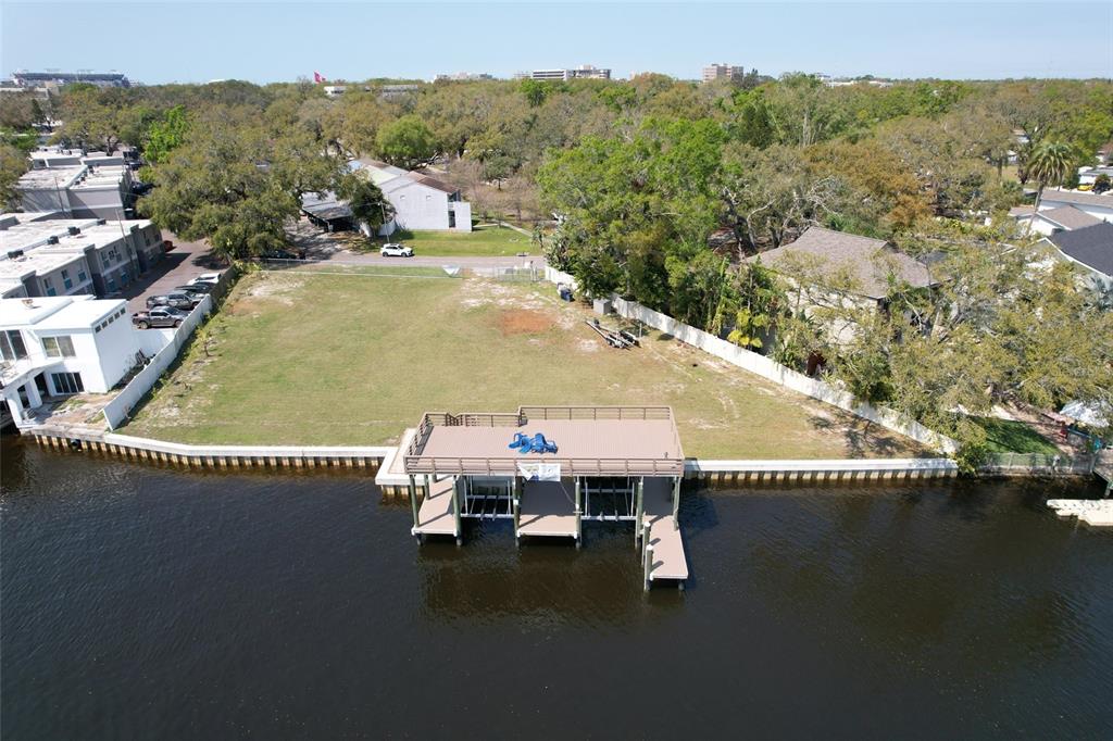 An aerial view shows a vacant waterfront lot featuring a large deck and boat lift — 4033 N RIVER VIEW AVENUE, TAMPA, FL