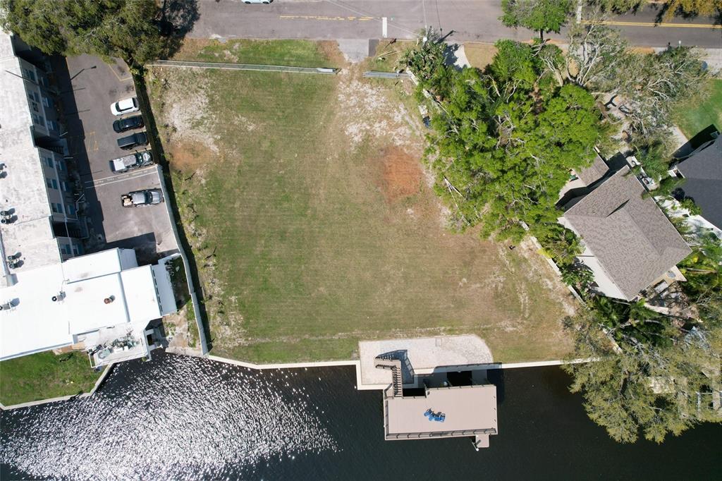 An aerial view shows a vacant waterfront lot with a dock and adjacent buildings — 4033 N RIVER VIEW AVENUE, TAMPA, FL