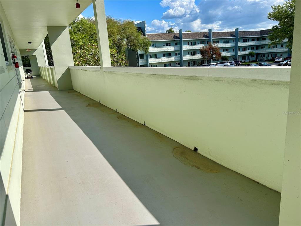 An outdoor covered balcony with a concrete floor and a low wall overlooking a parking lot — 2256 PHILIPPINE DRIVE UNIT 42, CLEARWATER, FL