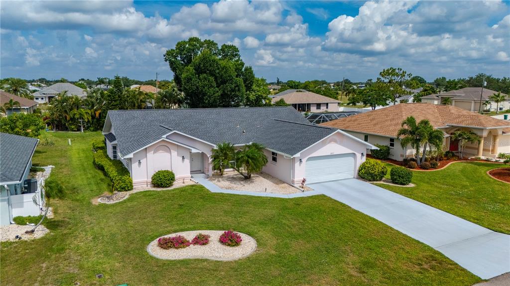 An aerial view shows a light pink, single-story house with a gray roof and driveway — 2231 HAMBURG LANE, PUNTA GORDA, FL