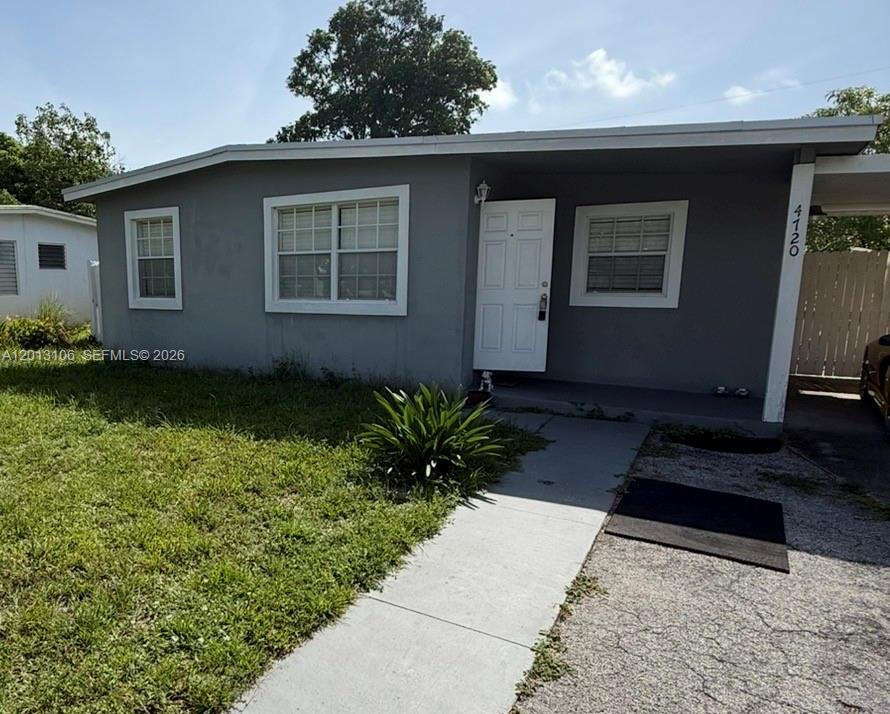 A single-story gray house features a white front door, white-trimmed windows, and a concrete walkway — 4720 NE 14th Ave, Pompano Beach FL 33064, POMPANO BEACH, FL