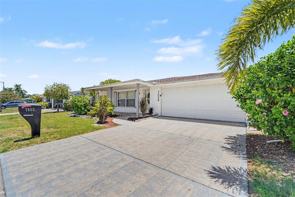 A single-story house with a white garage door, a concrete driveway, and a mailbox — 7006 MAPLEHURST DRIVE, PORT RICHEY, FL