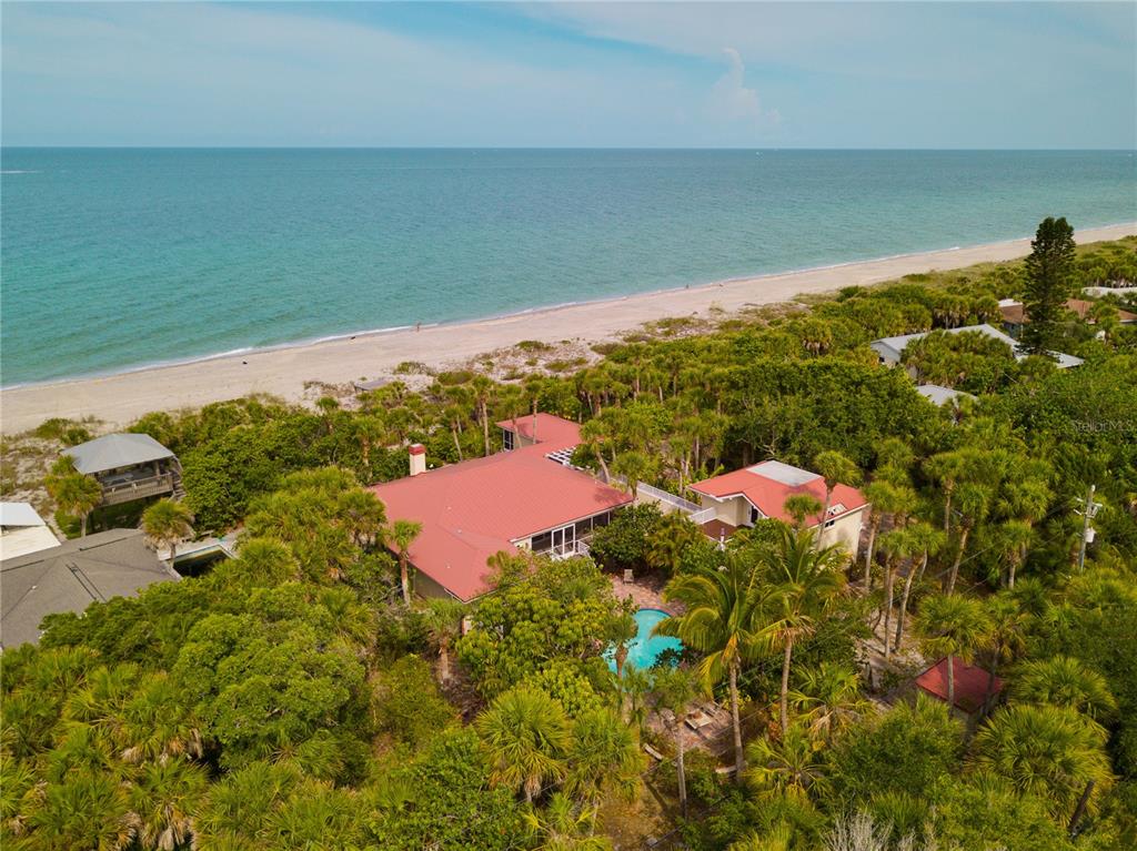 An aerial view shows a house with a red roof near a beach and ocean — 8300 MANASOTA KEY ROAD, ENGLEWOOD, FL