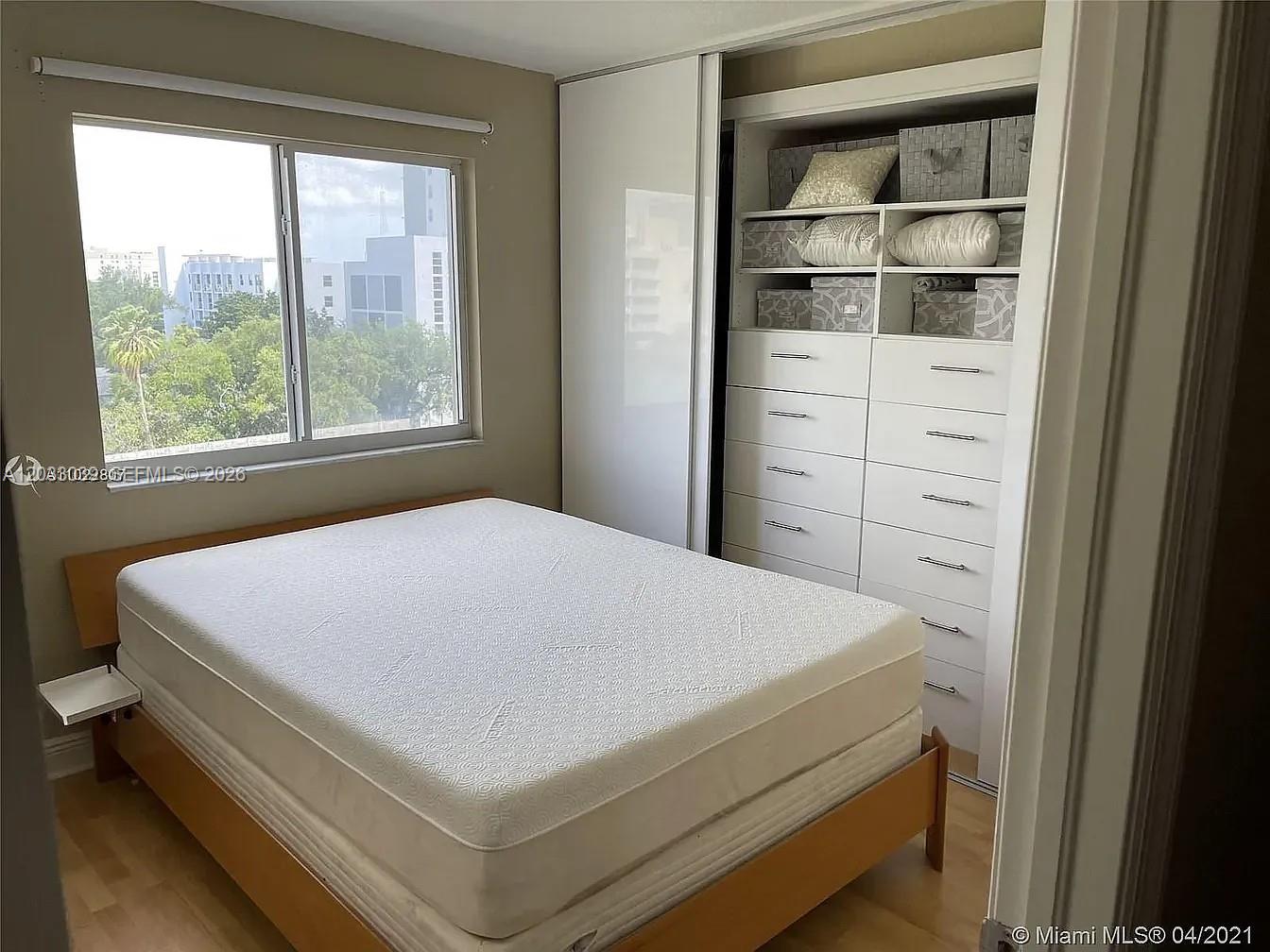 A bedroom features a mattress on a wooden frame, a window, and a built-in closet — 816 NW 11th St # 704, Miami FL 33136, MIAMI, FL