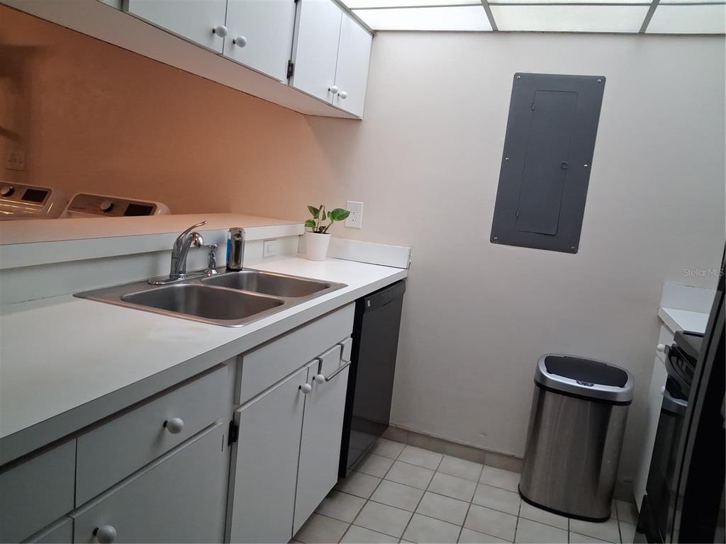 A kitchen features white cabinets, a double-basin sink, a dishwasher, and a tile floor — 3341 CAMELOT DRIVE UNIT 3341, HAINES CITY, FL