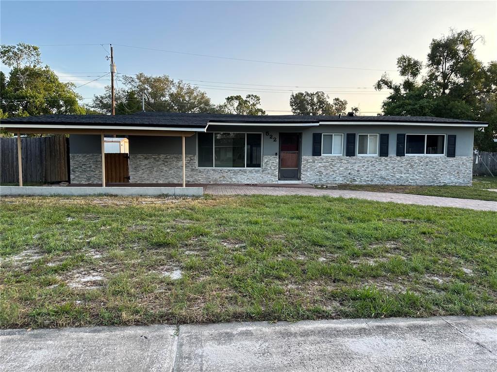 A single-story house with a stone facade, a carport, and a paved driveway — 522 WILSHIRE DRIVE, CASSELBERRY, FL