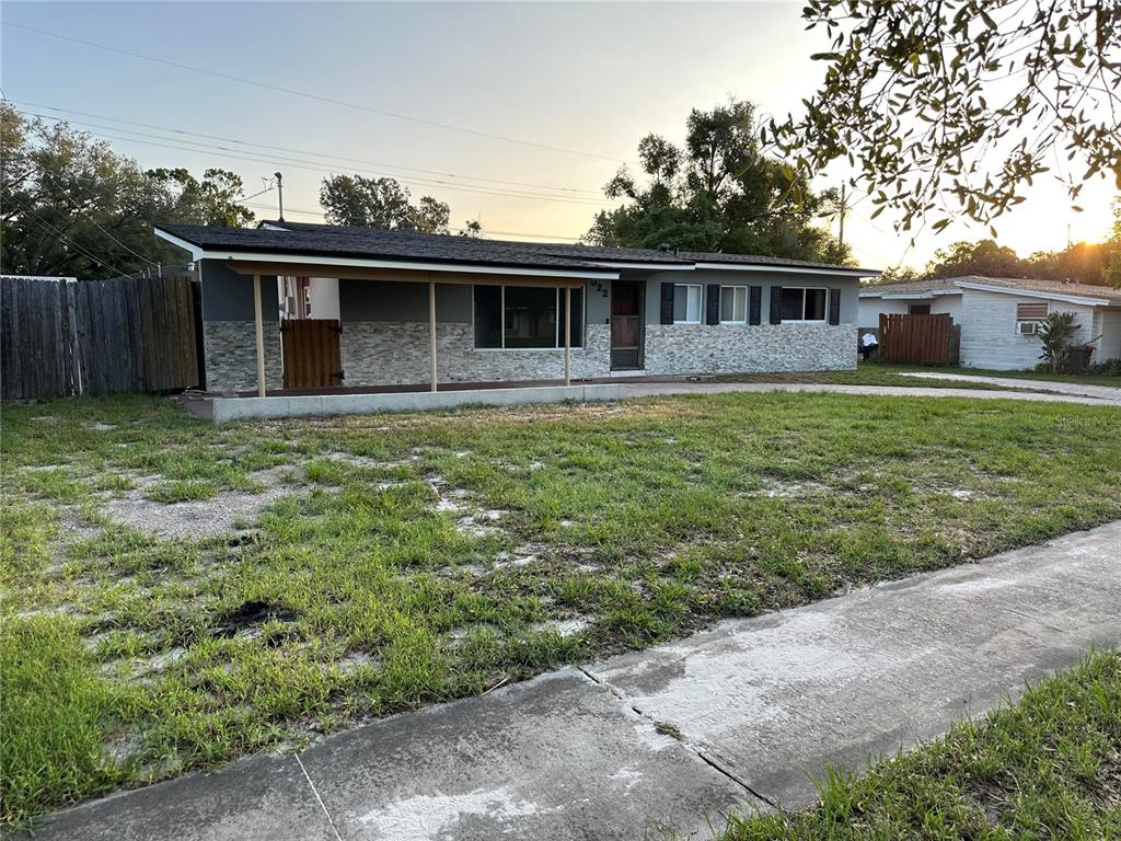 A single-story house with a stone facade, a covered front porch, and a grassy yard — 522 WILSHIRE DRIVE, CASSELBERRY, FL
