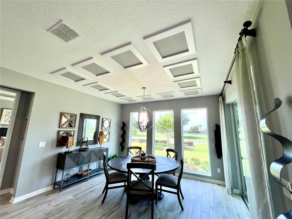 A dining room features a round table, gray walls, and a ceiling with recessed square panels — 9152 SW 85TH PLACE, OCALA, FL