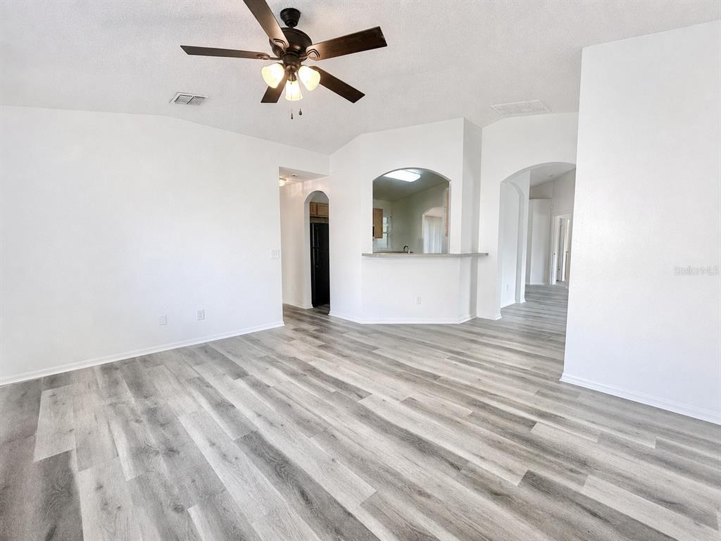 A living room with light gray wood-look flooring, white walls, and a ceiling fan — 2871 LOCKWOOD BOULEVARD, DELTONA, FL