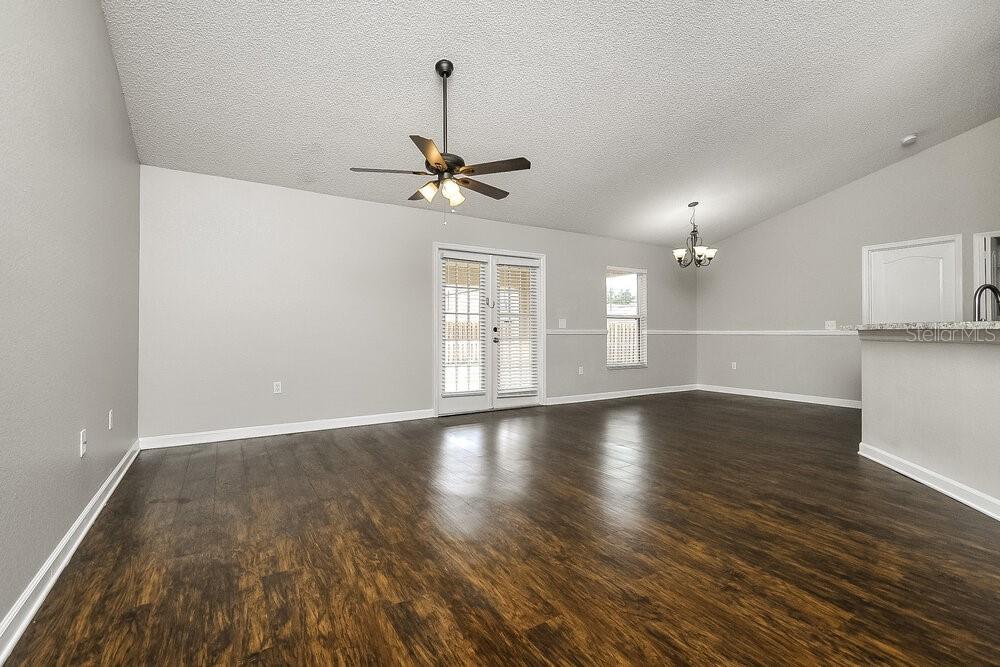 A living room with dark wood flooring, light gray walls, and a ceiling fan — 6025 LIVE OAK DRIVE, WINTER HAVEN, FL