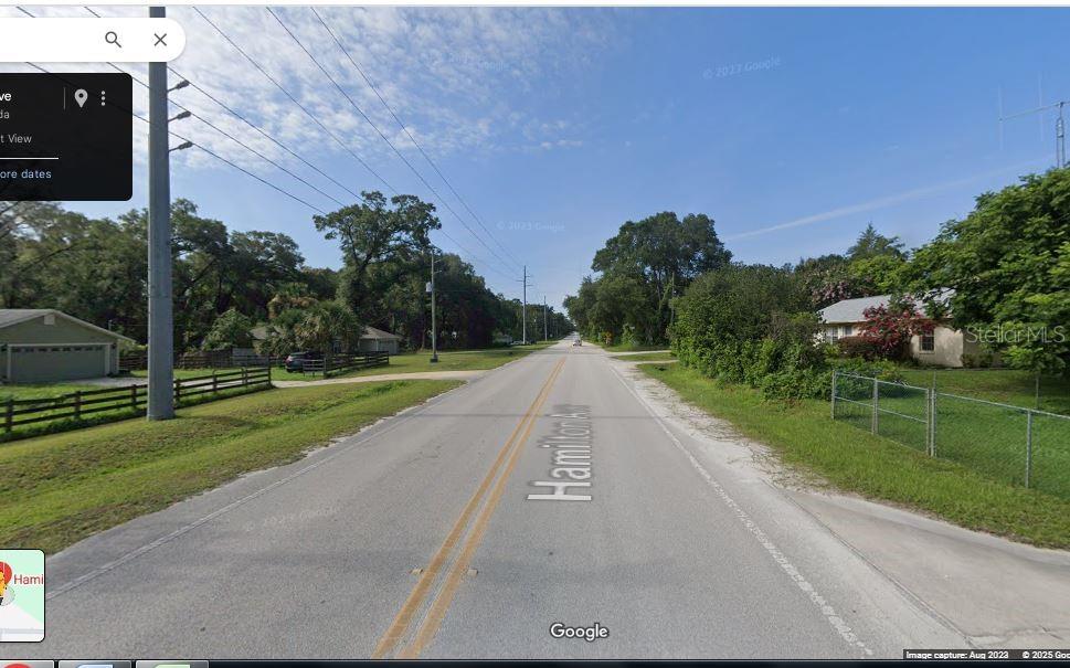 A street view shows a paved road lined with trees, utility poles, and residential houses — HAMILTON AVE, ORANGE CITY, FL