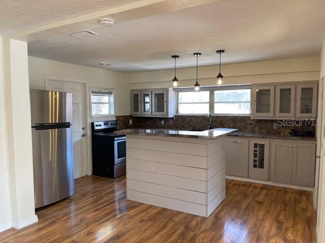 A kitchen features a central island, stainless steel refrigerator, and wood-look flooring — 1731 W SAINT LOUIS STREET, TAMPA, FL