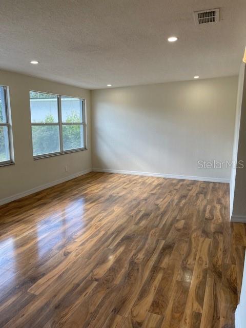 An empty room features light-colored walls, recessed lighting, and wood-look laminate flooring — 1731 W SAINT LOUIS STREET, TAMPA, FL