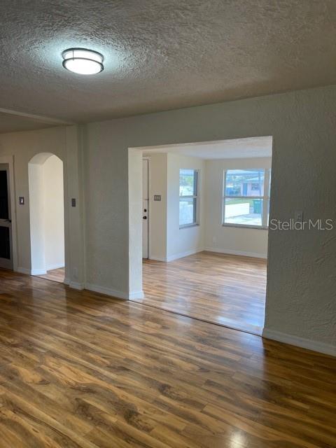 An interior view shows a living area with light wood-look flooring and a large opening — 1731 W SAINT LOUIS STREET, TAMPA, FL