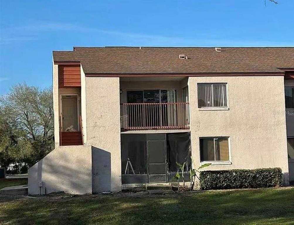 A two-story apartment building exterior features a balcony, a screened patio, and a staircase — 2562 LAKEWAY BRANCH DRIVE UNIT 3002, ORLANDO, FL