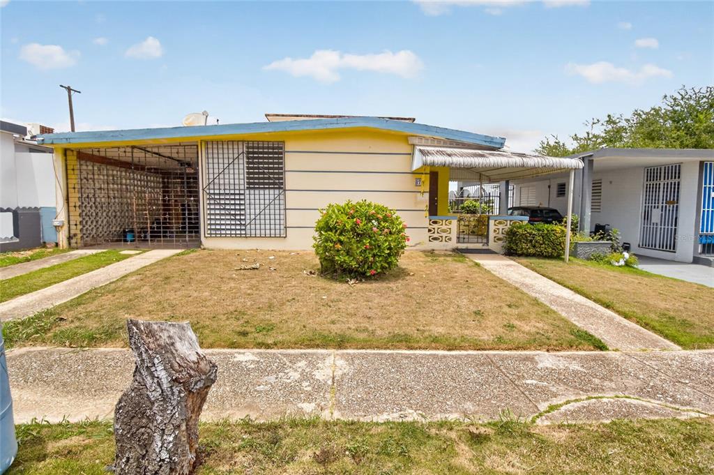 A single-story house with a yellow facade, a carport, and a small front yard — 3 URBANIZACIÓN REPARTO MARQUEZ UNIT BLQ B7, ARECIBO, PR