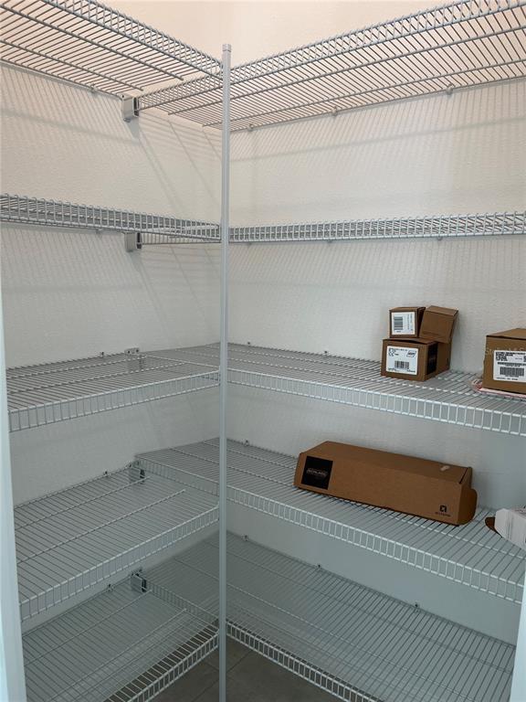 A walk-in pantry features white wire shelving installed on multiple levels along the walls — 5845 BISCOTTI ST, NOKOMIS, FL
