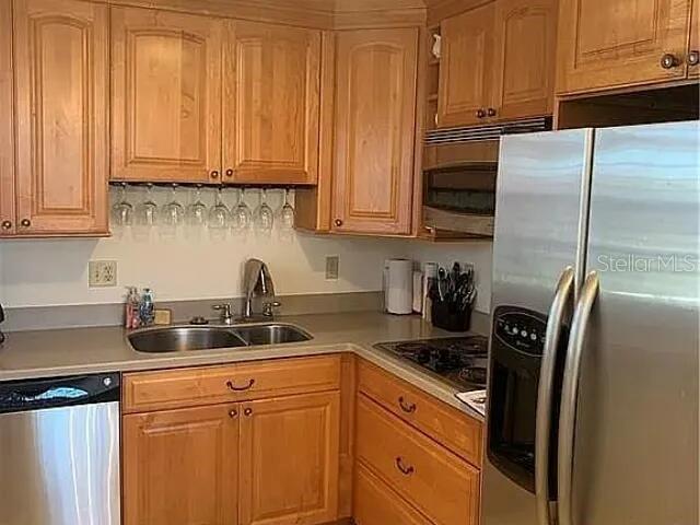 A kitchen features light wood cabinets, stainless steel appliances, and a double-basin sink — 94 SPRING LAKE DRIVE UNIT 203, VERO BEACH, FL