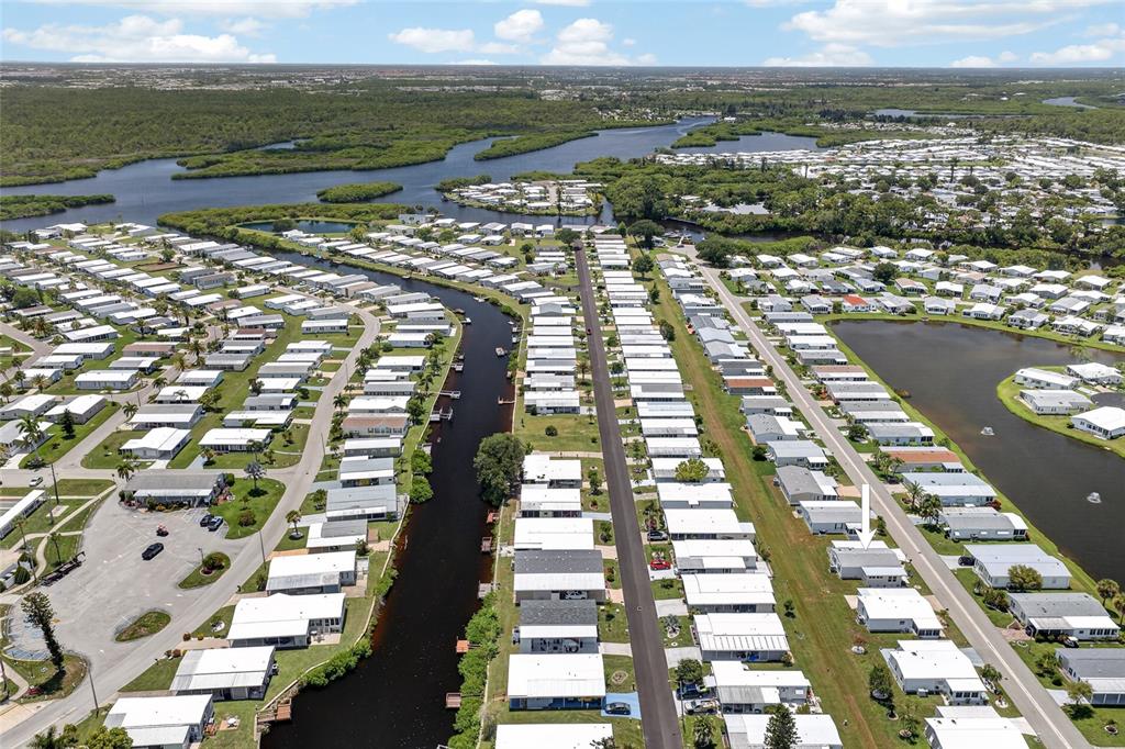 An aerial view of a mobile home community featuring a canal and a marked residence — 644 SCHOONER STREET, NORTH PORT, FL
