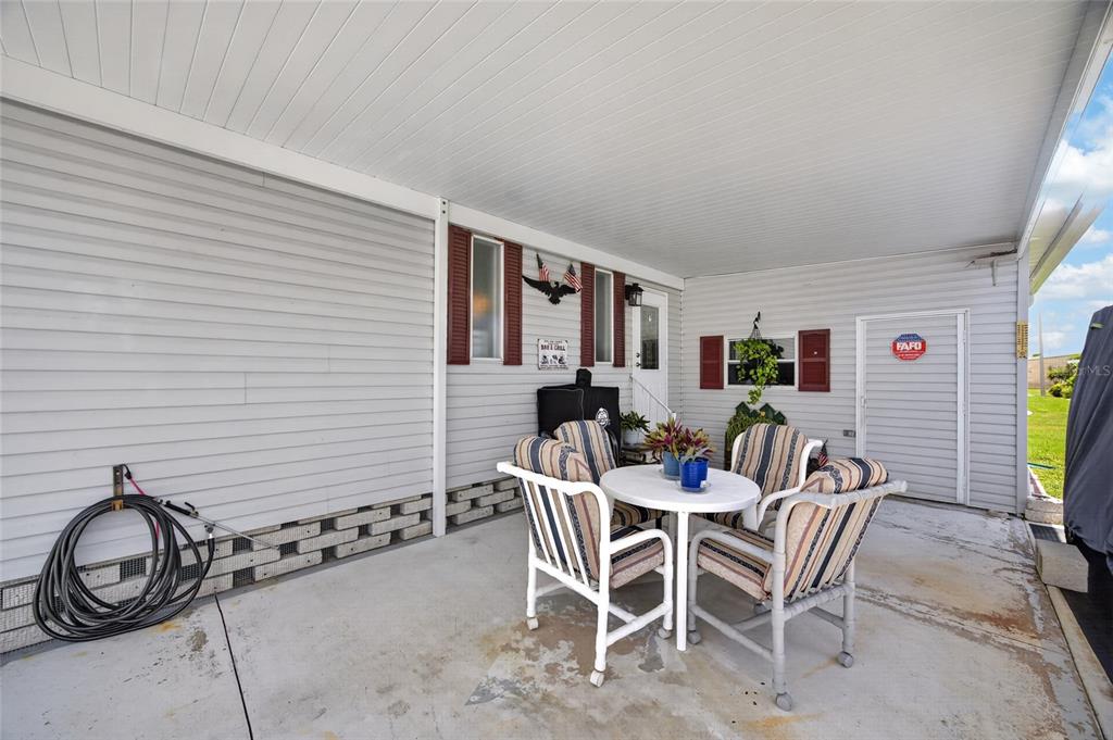 A covered patio features a white table with four chairs and light gray siding — 644 SCHOONER STREET, NORTH PORT, FL