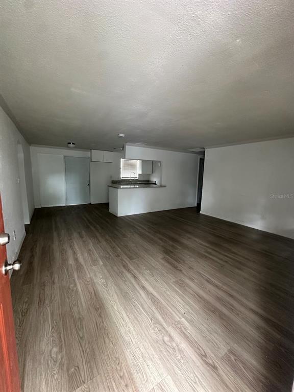 An open-concept living area features wood-look flooring and a kitchen with a breakfast bar — 2620 E 33RD AVENUE, TAMPA, FL