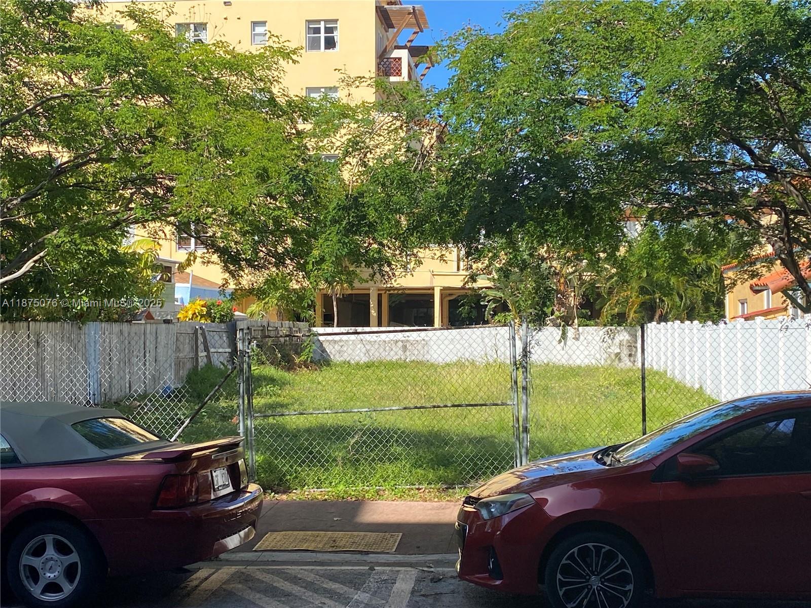 A fenced, grassy vacant lot sits between two parked cars in front of a building — 935 2nd St, Miami Beach FL 33139, MIAMI BEACH, FL