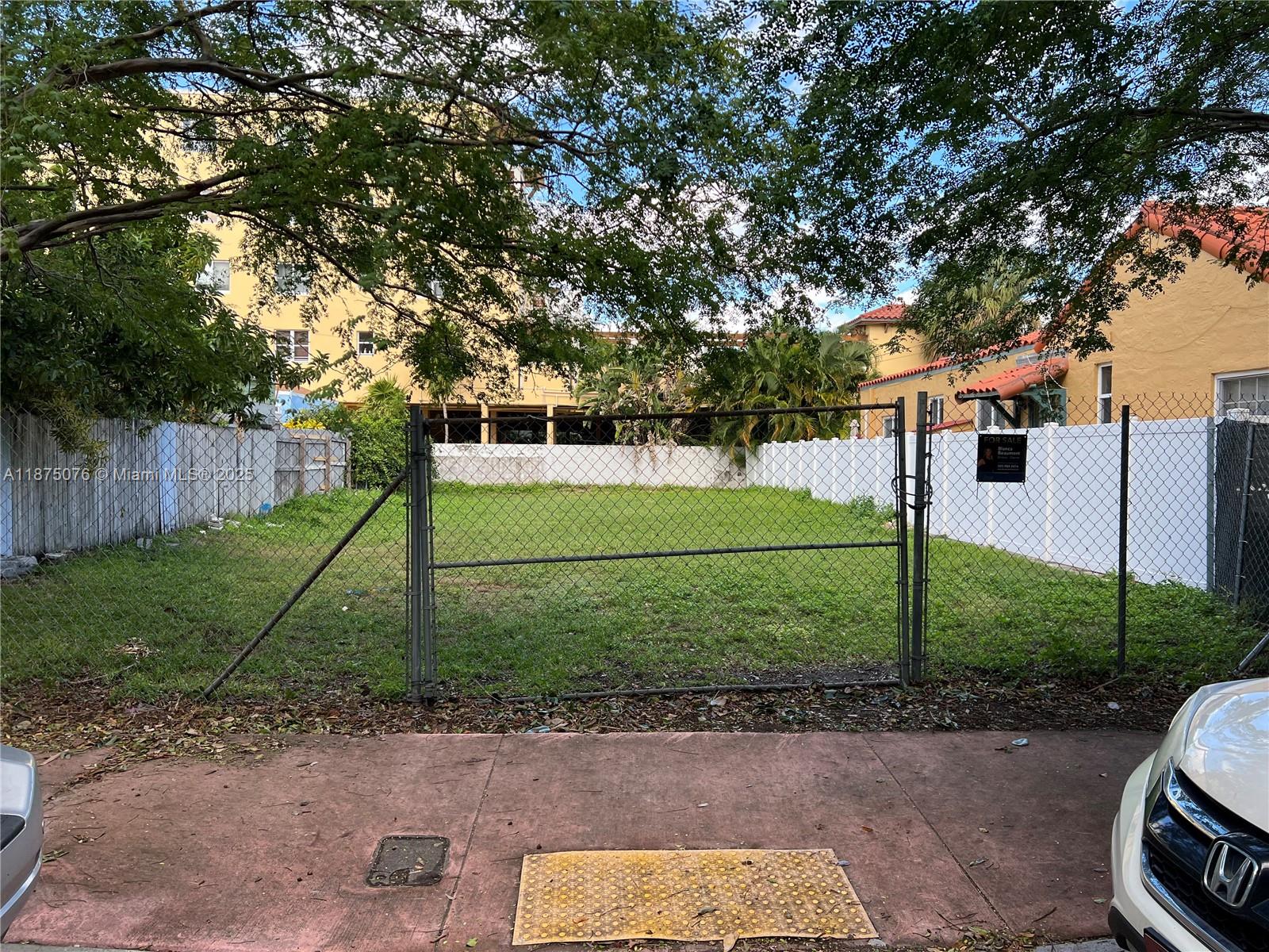 A fenced, vacant grassy lot sits between two buildings with a sidewalk in the foreground — 935 2nd St, Miami Beach FL 33139, MIAMI BEACH, FL