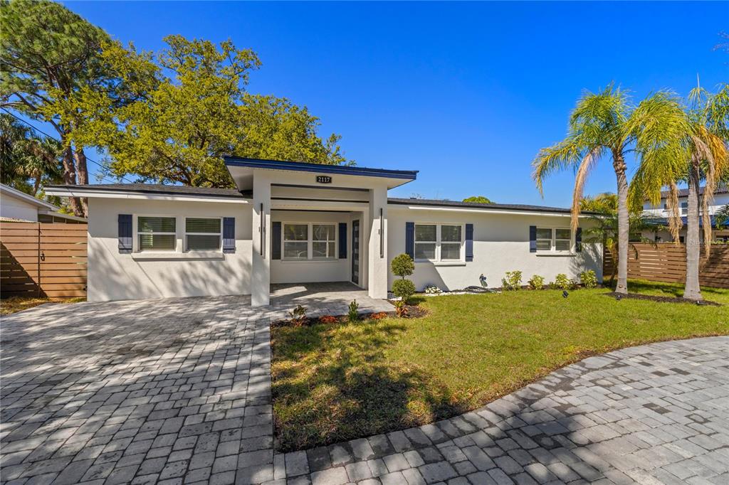 A single-story white house features a paved driveway, a covered entryway, and blue shutters — 2117 S WEST SHORE BOULEVARD, TAMPA, FL