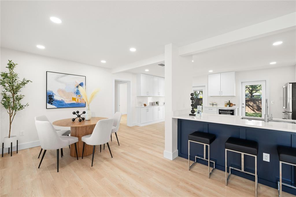 A dining area with a round table and a kitchen featuring a blue island — 2117 S WEST SHORE BOULEVARD, TAMPA, FL