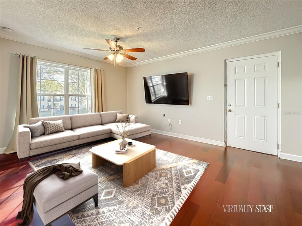 A living room features a sectional sofa, a coffee table, a television, and hardwood floors — 2071 DIXIE BELLE DRIVE UNIT 2071P, ORLANDO, FL