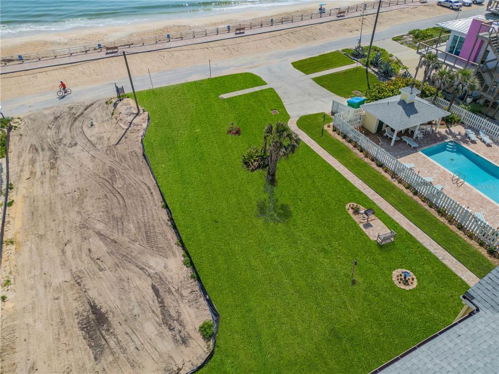 An aerial view shows a grassy yard, a swimming pool, and a beach boardwalk — 0 S ATLANTIC AVENUE, NEW SMYRNA BEACH, FL