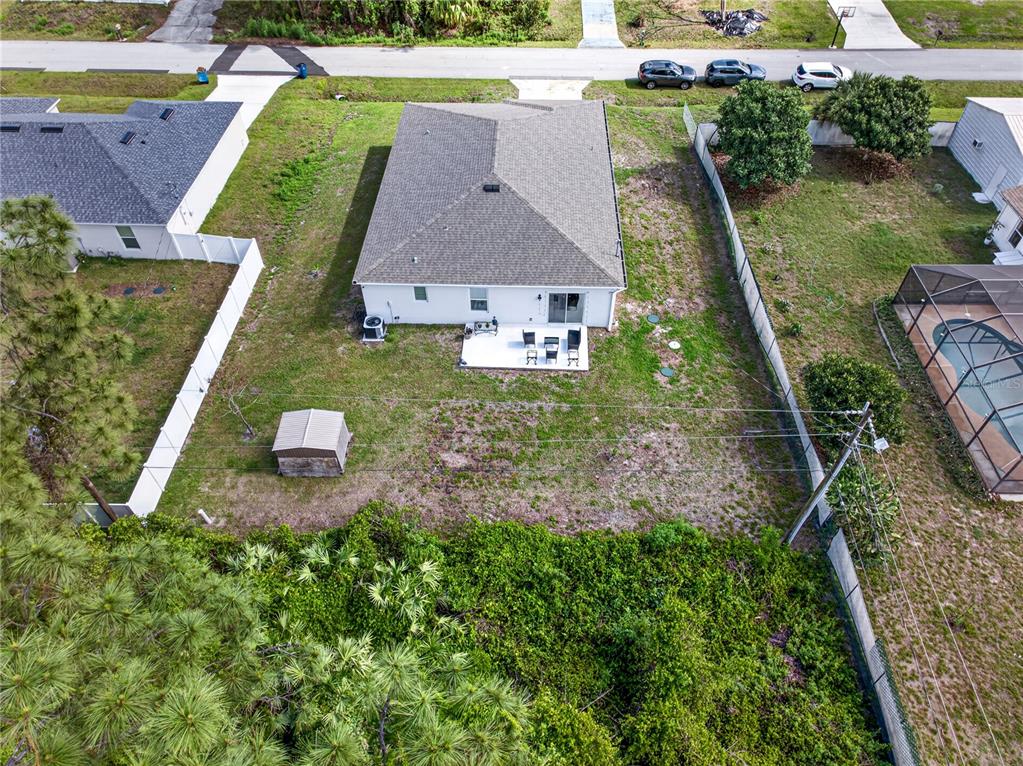 An aerial view shows a single-story house with a backyard, patio, and small shed — 180 DOLPHIN STREET SE, PALM BAY, FL