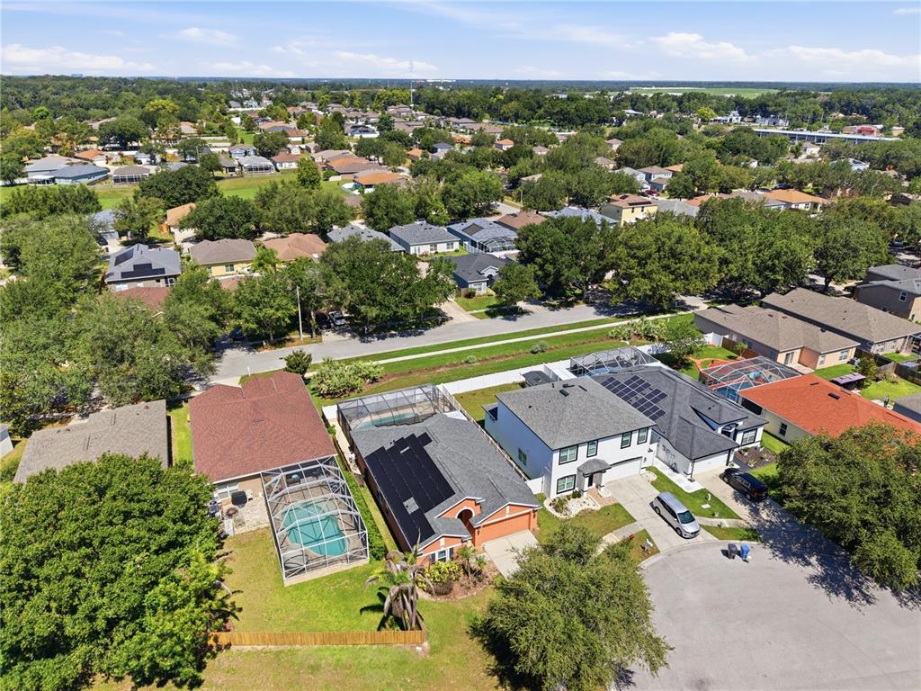 An aerial view shows several suburban houses with swimming pools and solar panels — 704 PARSONS POINTE ST, SEFFNER, FL
