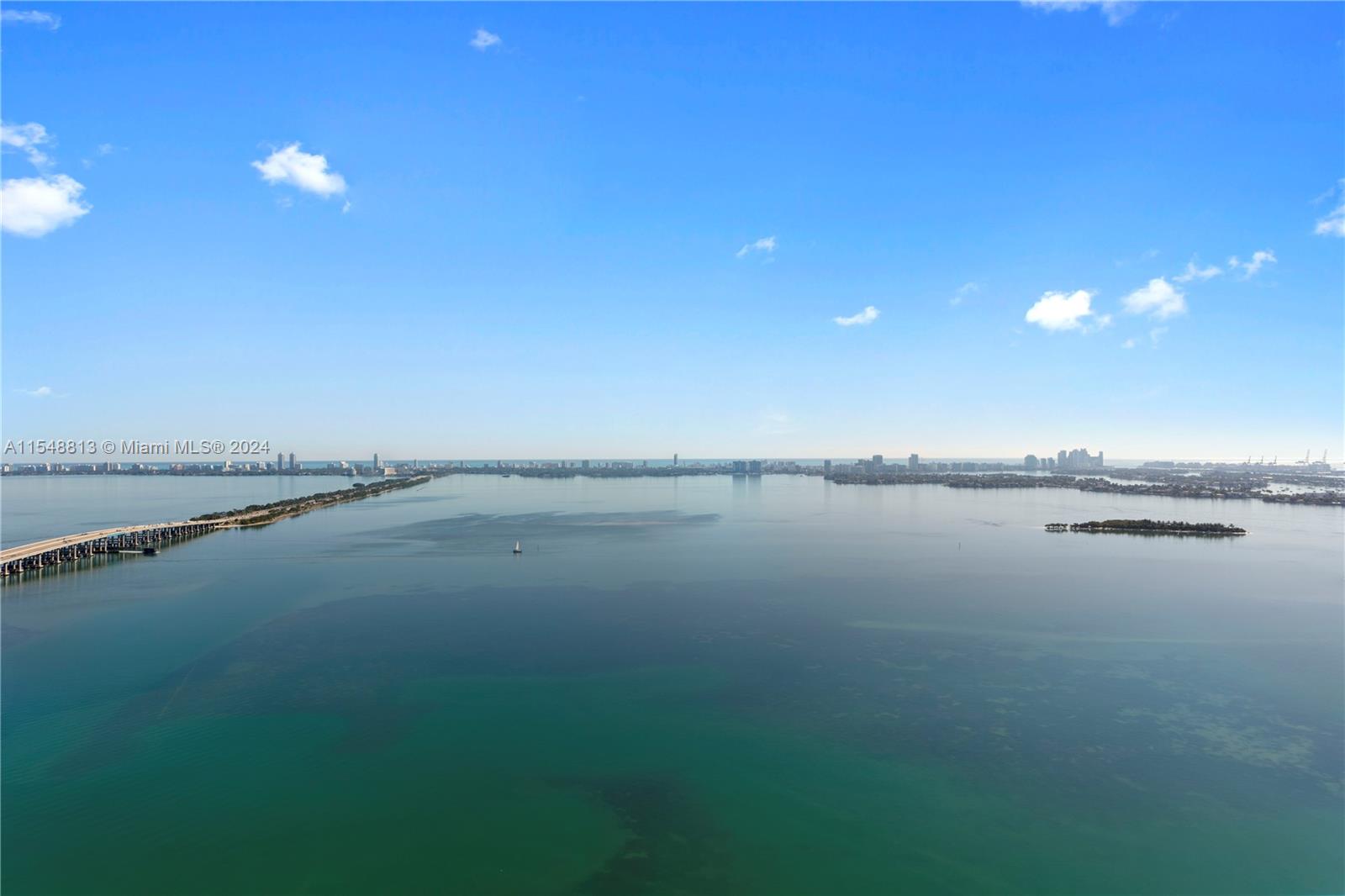 An aerial view shows a calm bay with a long bridge and distant city skyline — 480 NE 31st St # 2202, Miami FL 33137, MIAMI, FL