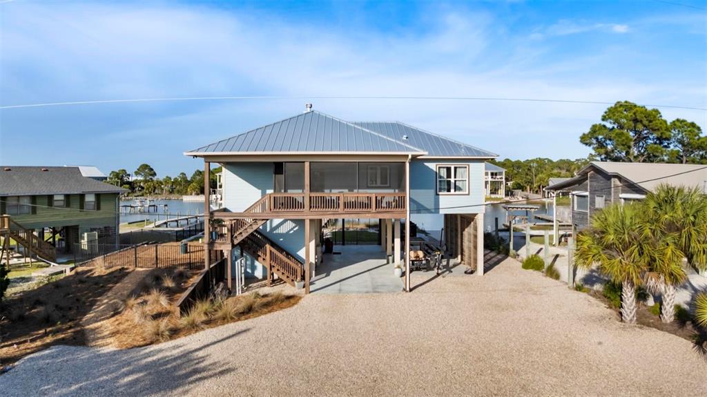 An elevated light blue house with a metal roof and a screened-in porch — 331 LAND STREET, EASTPOINT, FL