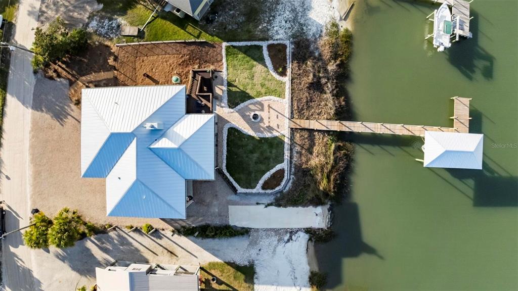 An aerial view shows a house with a metal roof, a backyard, and a dock — 331 LAND STREET, EASTPOINT, FL
