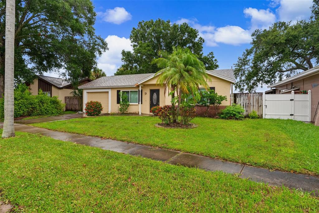 A single-story house with a tan exterior, a palm tree, and a white vinyl fence — 6470 107TH TERRACE, PINELLAS PARK, FL